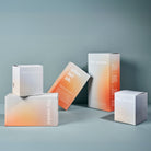 Anordnung von Schachteln der großen Wochenbetteinlagen, kleinen Wochenbettbinden und Stilleinlagen von the weeks vor blauem Hintergrund