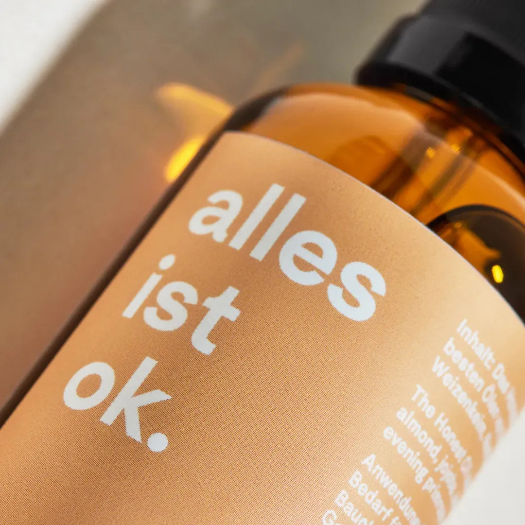 Nahaufnahme des "alles ist ok." auf der Flasche des Honest Oil Körperöls von the weeks