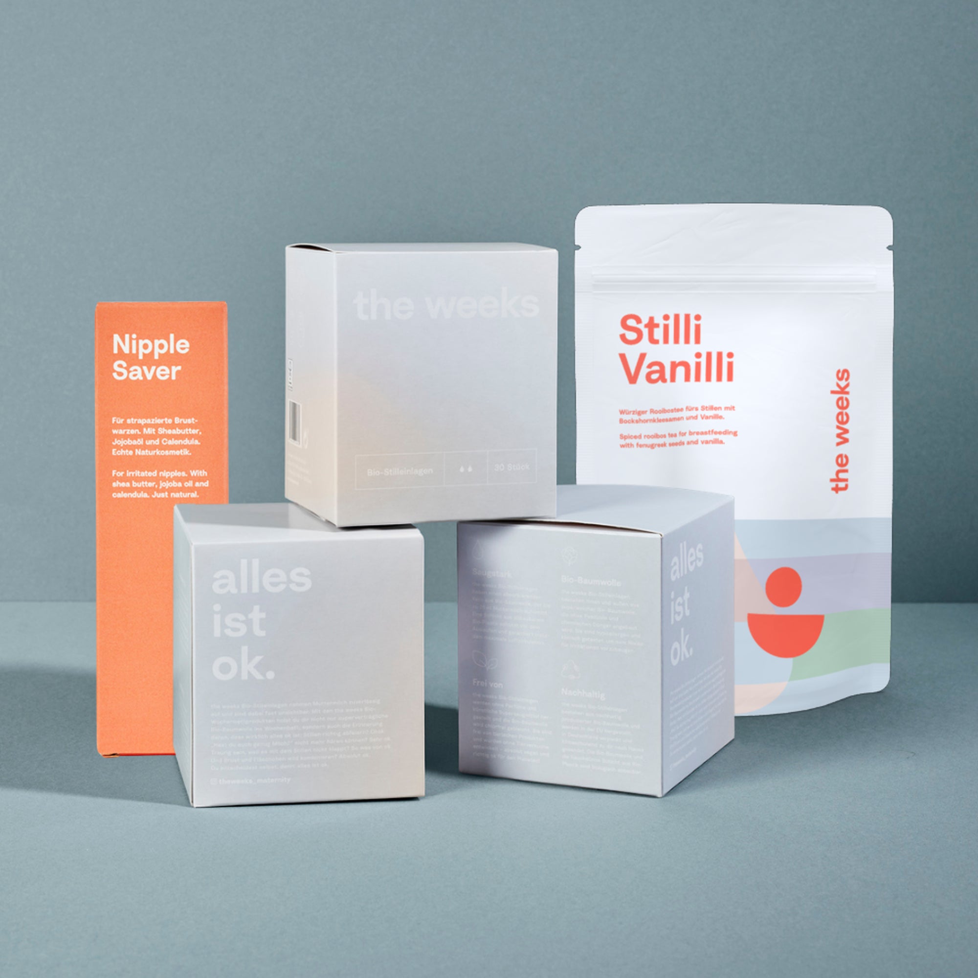 Stillstart-Bundle von the weeks. Es sind drei Packungen Stilleinlagen, eine Schahtel des Nippel Savers und ein Beutel mit dem Stilltee Stilli Vanilli zu sehen