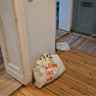 "alles ist ok."-Tasche von the weeks steht im Flur einer Altbauwohnung